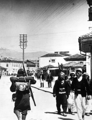 "Italian soldiers passing Albanians, 7 April 1939" by DIREKTOR via Wikimedia Commons (Public domain)