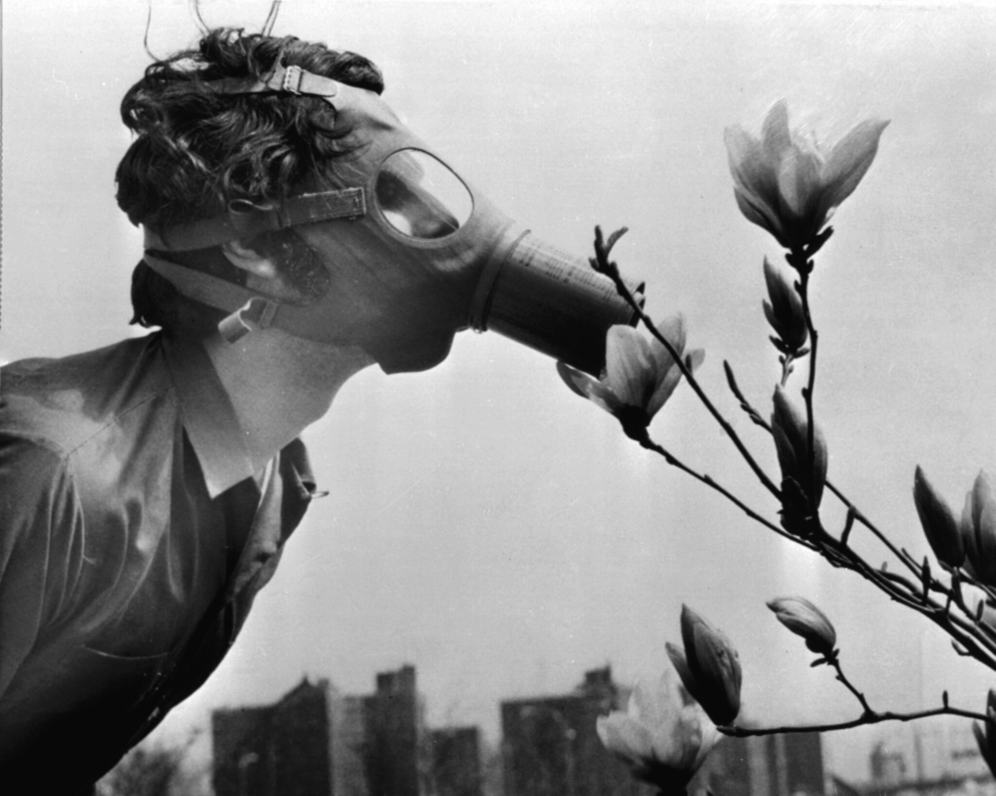 Pace college student in a gas mask “smells” a magnolia blossom in city hall park on earth day (April 22, 1970) in New York by Rogelio A. Galaviz C. on Flickr (CC BY-NC 2.0)