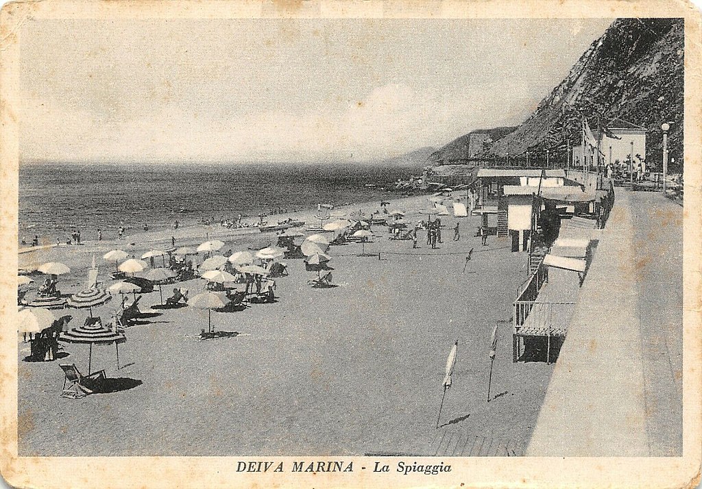 "Lungomare con spiaggia a Deiva Marina, sulla destra il fabbricato viaggiatori della vecchia stazione ferroviaria" by Unknown author via Wikimedia Commons (Public Domain) "Lungomare con spiaggia a Deiva Marina, sulla destra il fabbricato viaggiatori della vecchia stazione ferroviaria" by Unknown author via Wikimedia Commons (Public Domain)