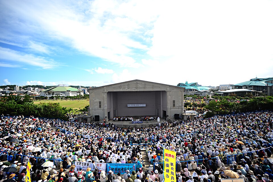 "A crowd of Okinawans protesting the Futenma base in Ginowan, Okinawa" by Nathan Keirn via Wikimedia Commons (CC BY-SA 2.0)
